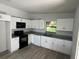 Updated kitchen with white cabinets, black appliances, and granite countertops at 1505 S Westmoreland Dr, Orlando, FL 32805