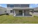 A covered patio and backyard with a well-maintained lawn and exterior home view at 1698 Sugarbelle Cir, Mascotte, FL 34753