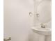 Bathroom with pedestal sink, chrome hardware and round decorative mirror at 1698 Sugarbelle Cir, Mascotte, FL 34753