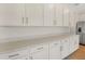 Well lit kitchen featuring lots of white cabinets with modern pulls and beautiful quartz countertops at 1698 Sugarbelle Cir, Mascotte, FL 34753