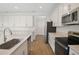 Spacious kitchen featuring stainless steel appliances and bright white cabinetry with lots of storage space at 1698 Sugarbelle Cir, Mascotte, FL 34753