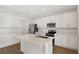 Bright and modern kitchen with white cabinetry, stainless steel appliances, and center island at 1698 Sugarbelle Cir, Mascotte, FL 34753