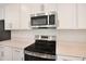 Close up of kitchen with stainless steel oven, microwave, white cabinets and quartz countertops at 1698 Sugarbelle Cir, Mascotte, FL 34753