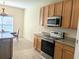 Kitchen with wood cabinets, granite countertops, and stainless steel appliances at 753 Largo Pass, Poinciana, FL 34759