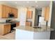 Well-lit kitchen with stainless steel appliances, granite countertops, and light wood cabinetry at 753 Largo Pass, Poinciana, FL 34759