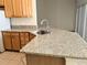 Spacious kitchen with granite countertops, stainless steel sink, and wood cabinetry at 753 Largo Pass, Poinciana, FL 34759
