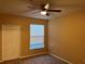 Cozy bedroom with a ceiling fan, window with blinds and ample natural light at 8830 Dunes Ct # 12 207, Kissimmee, FL 34747