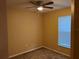 Empty bedroom with a ceiling fan, window with blinds and neutral colored walls at 8830 Dunes Ct # 12 207, Kissimmee, FL 34747