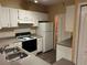 Well-lit kitchen featuring white cabinets, modern appliances, and a spacious double sink at 8830 Dunes Ct # 12 207, Kissimmee, FL 34747