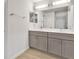 Bathroom with double sink vanity featuring gray cabinets and a large mirror at 314 Dagama Ct, Kissimmee, FL 34758