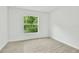 Bright bedroom with wood-look tile floors and a large window showcasing a lush green view at 314 Dagama Ct, Kissimmee, FL 34758