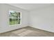 Bright bedroom featuring wood-look tile floors and a window showcasing a view of trees and lawn at 314 Dagama Ct, Kissimmee, FL 34758