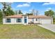 Charming single-story home with white exterior, brown roof, blue shutters and well-manicured lawn at 314 Dagama Ct, Kissimmee, FL 34758