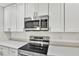 Close up of stainless steel microwave and glass top range in modern kitchen with quartz countertops at 314 Dagama Ct, Kissimmee, FL 34758