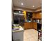 Functional kitchen with stainless steel refrigerator, tile floors, and wood cabinets at 425 Blue Jacket Ln, Orlando, FL 32825