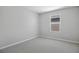 Neutral-colored bedroom with gray carpet and walls, with a window letting in natural light at 5414 Catmint Dr, Lake Hamilton, FL 33851