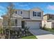 Two-story home featuring a two-car garage, neutral siding, and a well-manicured lawn at 5414 Catmint Dr, Lake Hamilton, FL 33851