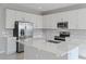 Bright, open kitchen featuring a large island, stainless steel appliances, and white cabinetry at 5414 Catmint Dr, Lake Hamilton, FL 33851