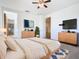 Primary bedroom with modern dresser and mounted TV at 663 Irvine Ranch Rd, Poinciana, FL 34759