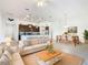 Open concept living and dining area with beige sofa and wooden coffee table at 663 Irvine Ranch Rd, Poinciana, FL 34759