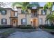Charming two-story townhome featuring a small balcony, well-maintained landscaping and beautiful palm trees at 733 Calabria Ave, Davenport, FL 33897