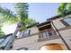 A low angle shot of a charming two-story townhome featuring a small balcony and brown trim at 733 Calabria Ave, Davenport, FL 33897