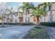 Charming two-story townhome featuring a small balcony, well-maintained landscaping and beautiful palm trees at 733 Calabria Ave, Davenport, FL 33897