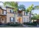 Charming two-story townhome featuring a small balcony, well-maintained landscaping and beautiful palm trees at 733 Calabria Ave, Davenport, FL 33897