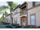 Charming two-story townhome featuring a small balcony, well-maintained landscaping and beautiful palm trees at 733 Calabria Ave, Davenport, FL 33897