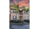 Charming two-story townhome featuring a small balcony, well-maintained landscaping and beautiful palm trees at 733 Calabria Ave, Davenport, FL 33897