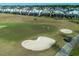 Aerial view of a golf course with people golfing near a sand trap and surrounding homes at 890 Pebble Beach Dr, Davenport, FL 33896