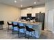 Modern kitchen features white cabinets, stainless steel appliances, an island, and a breakfast bar with seating at 890 Pebble Beach Dr, Davenport, FL 33896