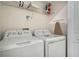 Functional laundry area features a washer, dryer, shelving, and storage space at 890 Pebble Beach Dr, Davenport, FL 33896