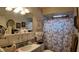 Bathroom featuring an Eiffel Tower patterned shower curtain, framed art, and vanity with sink and storage at 1600 W Lake Parker Dr # B23, Lakeland, FL 33805