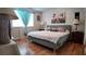 Bedroom featuring bed with beach art piece, window with drapes, and bedside lamps; showcasing cozy ambiance at 1600 W Lake Parker Dr # B23, Lakeland, FL 33805