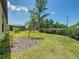 Spacious backyard with green grass, tropical trees, and a screened-in patio at 195 Casavista Dr, Kissimmee, FL 34759