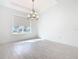A dining room featuring a chandelier, large window, and neutral walls, ready for your personal touch at 195 Casavista Dr, Kissimmee, FL 34759