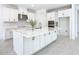 Modern white kitchen with island, quartz countertops, stainless steel appliances and wood-look flooring at 195 Casavista Dr, Kissimmee, FL 34759