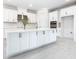This kitchen features white cabinets with stainless steel hardware and a large island with a quartz countertop at 195 Casavista Dr, Kissimmee, FL 34759