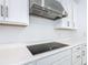 Close-up on the kitchen features quartz counters, stainless hood, and an electric cooktop at 195 Casavista Dr, Kissimmee, FL 34759