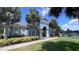 Community clubhouse surrounded by palm trees and lush landscaping by a lake at 10786 Savannah Wood Dr # 126, Orlando, FL 32832