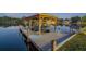 Private boat dock with covered area and lift at twilight at 1465 Riviera Dr, Kissimmee, FL 34744