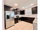 Modern kitchen showcasing stainless steel appliances, granite counters, dark wood cabinets, and a tile backsplash at 1940 Banner Ln, St Cloud, FL 34769