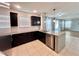 Beautiful kitchen featuring granite countertops, stainless steel appliances, dark wood cabinetry, and tile flooring at 1940 Banner Ln, St Cloud, FL 34769
