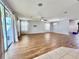 Expansive living room featuring wood floors, modern ceiling fan, and sliding glass doors that fill the space with natural light at 1940 Banner Ln, St Cloud, FL 34769