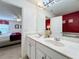 Bright bathroom featuring a double vanity with white cabinets, modern fixtures, and an adjoining bedroom view at 4191 Oaktree Drive, Davenport, FL 33837