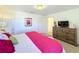 Comfortable bedroom with a large dresser, soft lighting, and a bright doorway view at 4191 Oaktree Drive, Davenport, FL 33837