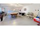 Spacious garage game room with a pool table, foosball table, and ample storage space at 4191 Oaktree Drive, Davenport, FL 33837