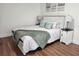 This comfortable bedroom has white furniture and calming decor, with wood-look floors and natural light at 4950 Nova Ave, St Cloud, FL 34773