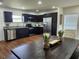 Open dining room with view of kitchen, a large wooden table and 6 upholstered chairs at 4950 Nova Ave, St Cloud, FL 34773